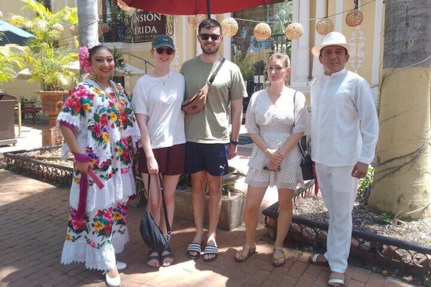 Un groupe de personnes se tient devant un restaurant qui dispose d’une terrasse. 1