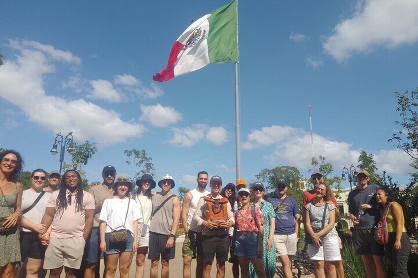 Un groupe de personnes se tient devant un mât sur lequel flotte un drapeau. 3