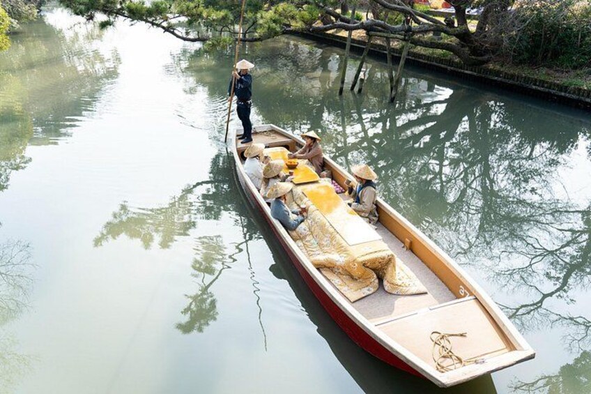 A narrow boat with passengers and a guide on a calm river. 2