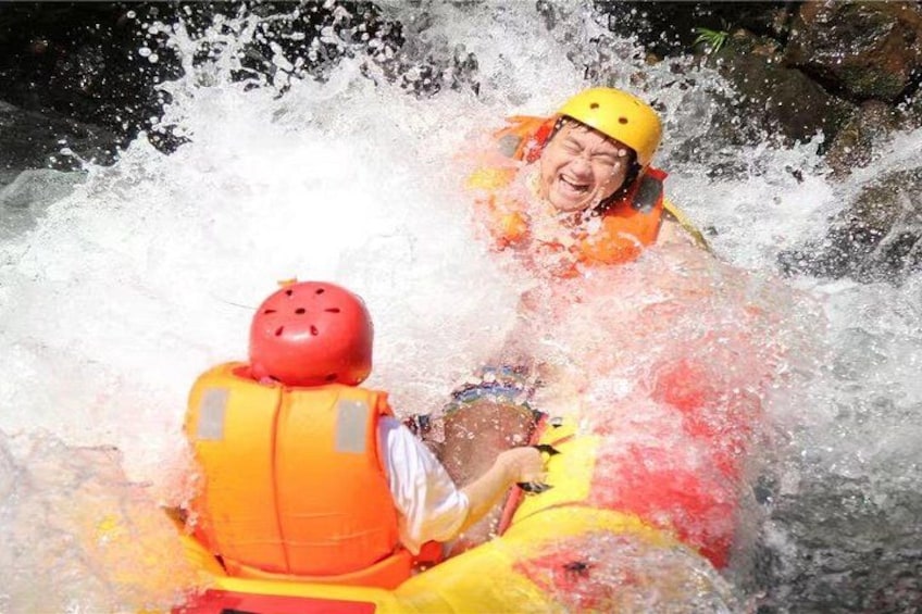 Two people in a white raft with red helmets navigating through a turbulent river. 1