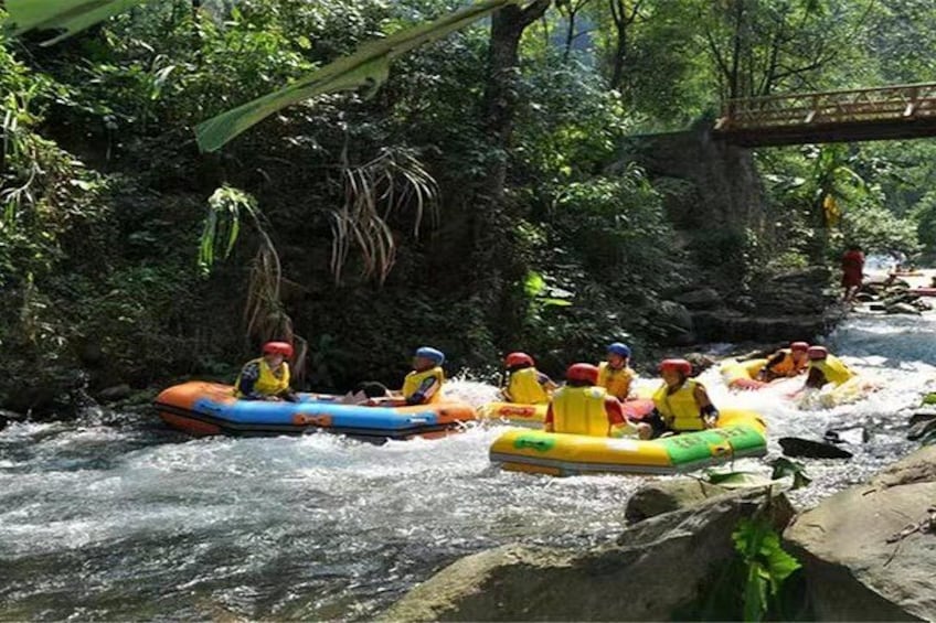 People rafting down a river surrounded by dense greenery. 4