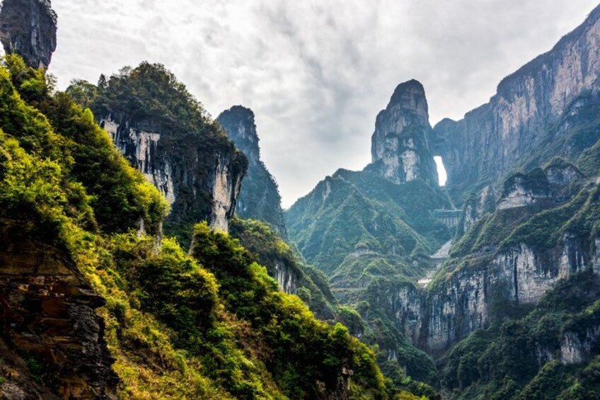 A mountainous landscape with lush greenery and prominent rock formations. 2