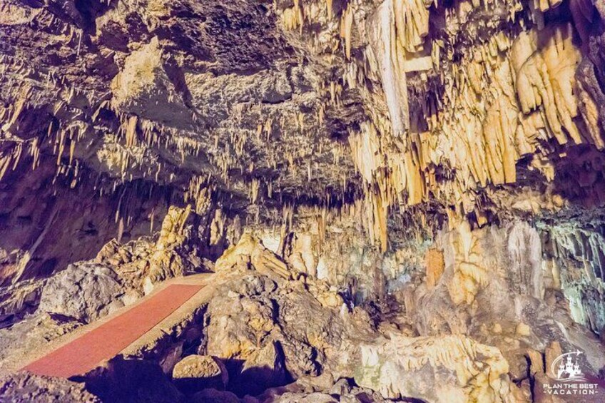 Una grotta con stalattiti e un percorso pedonale rosso. 4