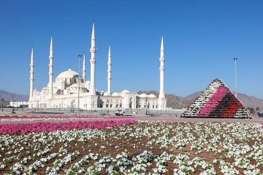 A mosque with multiple minarets, a large dome, and a colorful triangular structure. 4