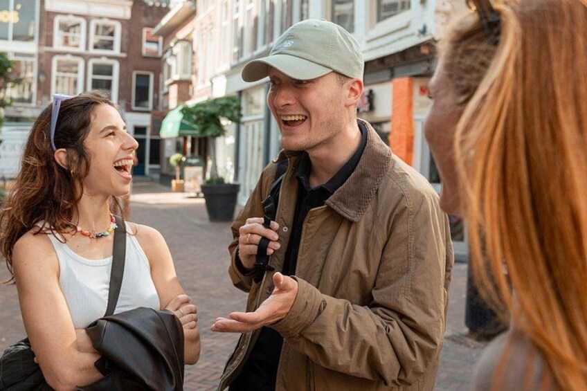 A street scene with buildings, a person gesturing, and another person with a backpack. 4