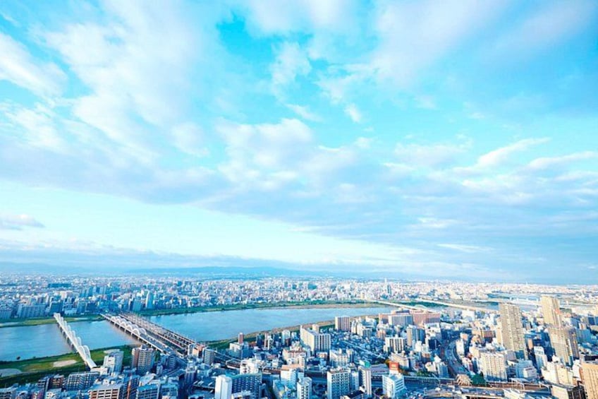 A cityscape with a river, a bridge, and a distant mountain range. 3