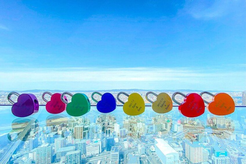 A cityscape with a row of heart-shaped locks on a bridge. 2