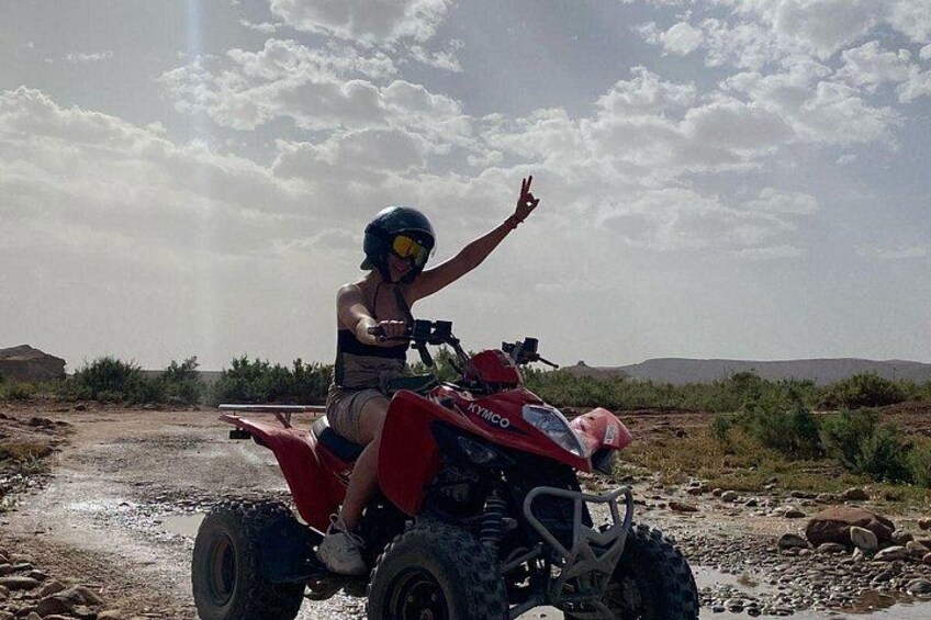 En person kører på en rød ATV i et ørkenlandskab. 4