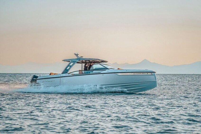 A speedboat on water with mountains in the background. 4