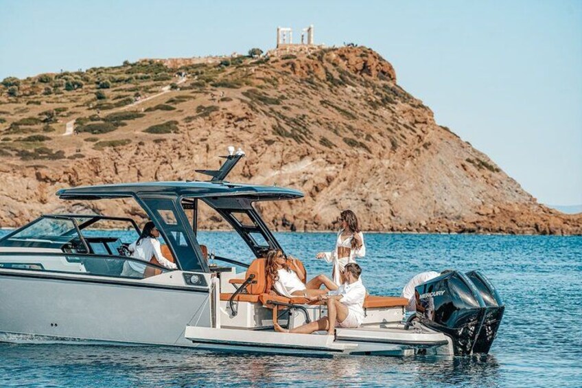 A boat with people on it near a rocky island with a lighthouse. 5