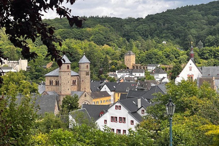 A town with historic buildings, a church, and a hill in the background. 5