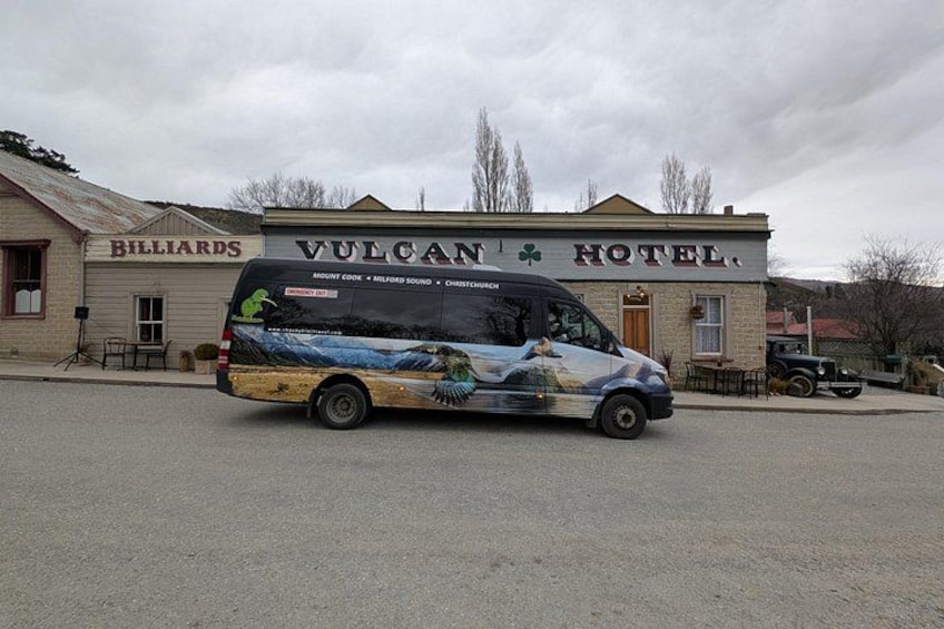 A bus parked in front of the Vulcan Hotel, with a building labeled 'Billiards' in the background. 4