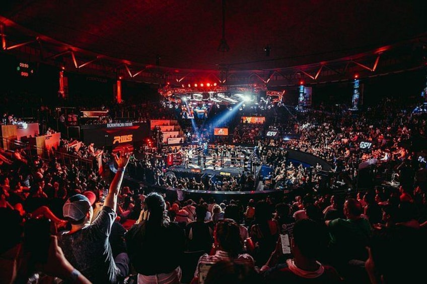 A crowded indoor event with a stage and audience. 4