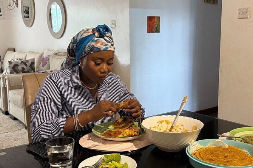 A person sitting at a table with a plate of food, a bowl of soup, and a glass of water. 5