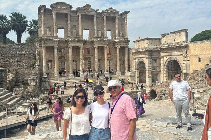 Ancient ruins with columns and arches, tourists walking around, and a clear sky. 3