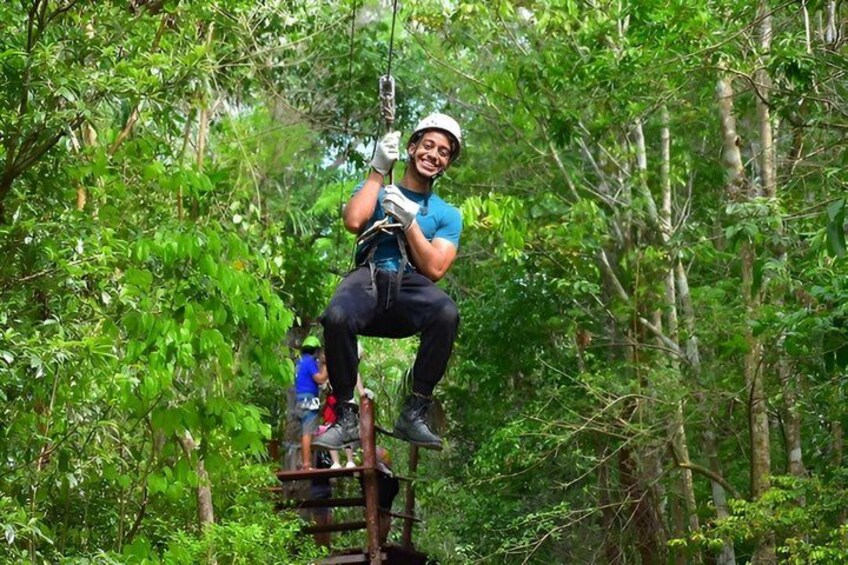 En person som åker på en zipline genom en tät skog. 4