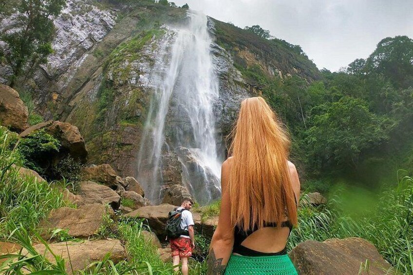 Una cascada, una persona con el cabello largo y otra persona con una mochila. 2