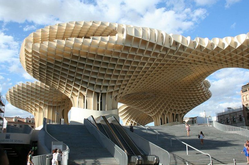 Een groot, modern architectonisch gebouw met een opvallend, gebogen dakontwerp. 3