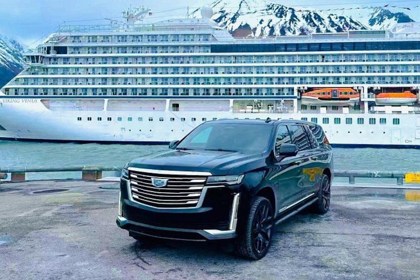 Ein schwarzer SUV vor einem Kreuzfahrtschiff namens 'Viking Venus', mit Bergen im Hintergrund. 1