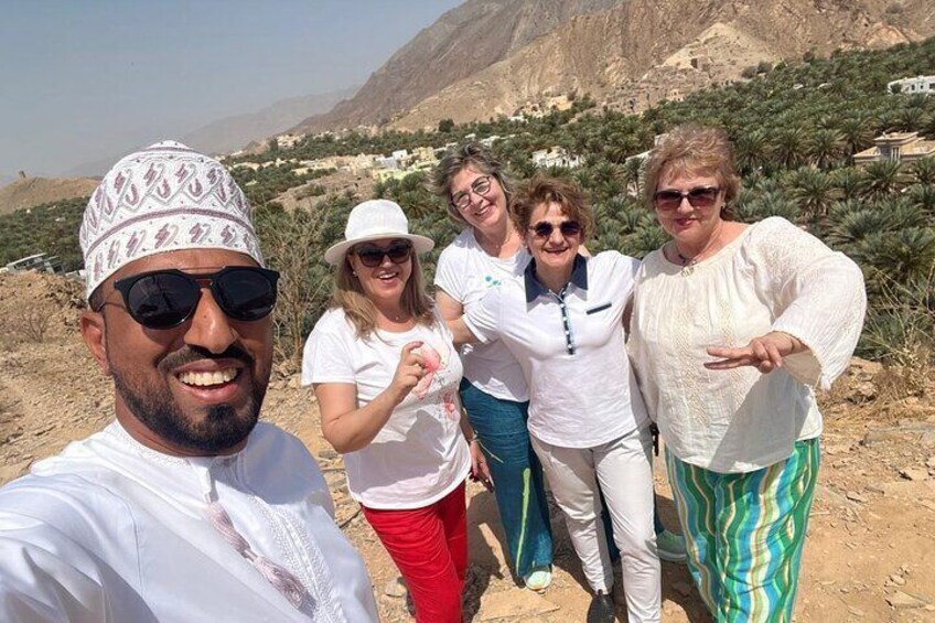 Un grupo de personas posando en un paisaje desértico con montañas al fondo. 1