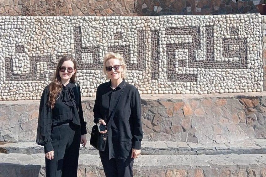 Due persone davanti a un muro decorato con mosaici. 4