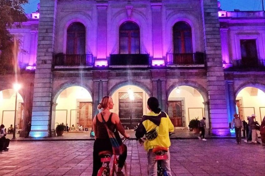 Un edificio histórico con arcos y columnas, iluminado con una luz púrpura. 3