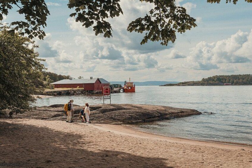 A sandy beach with a red building and a boat in the water. 4