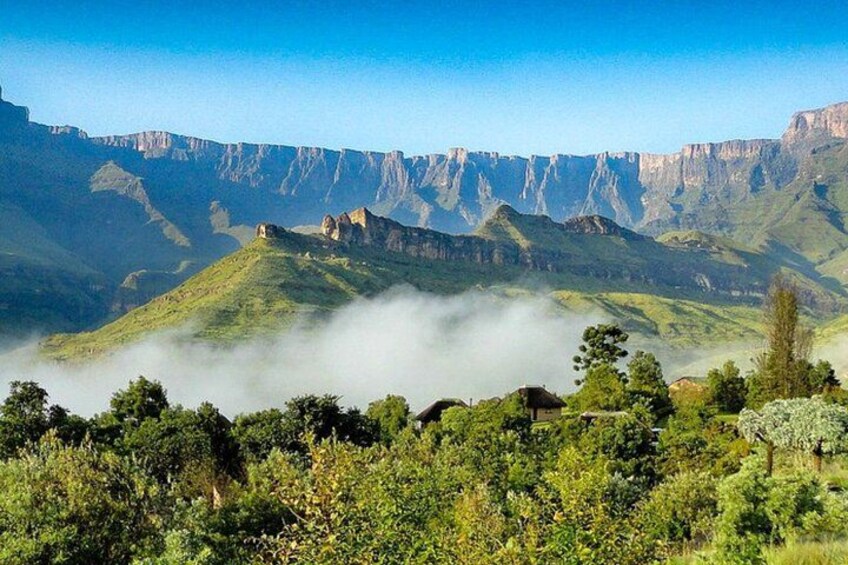 A mountainous landscape with green hills, a valley, and a clear sky. 4