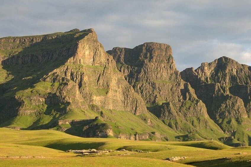 A mountainous landscape with green hills and rocky cliffs. 5