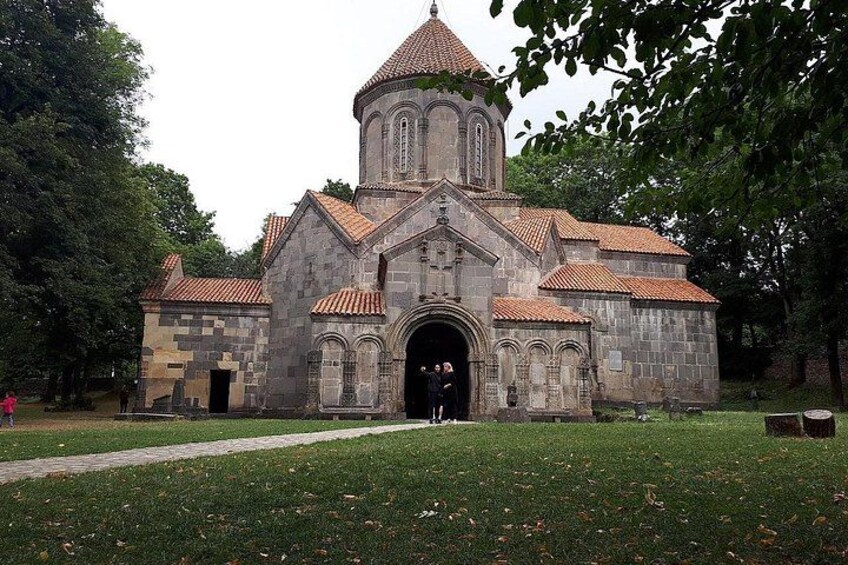 A stone church with a tiled roof and a bell tower. 3