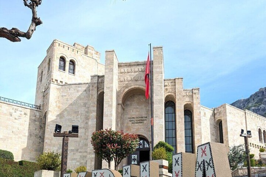 Un edificio storico con finestre ad arco e un'asta sventolante. 5