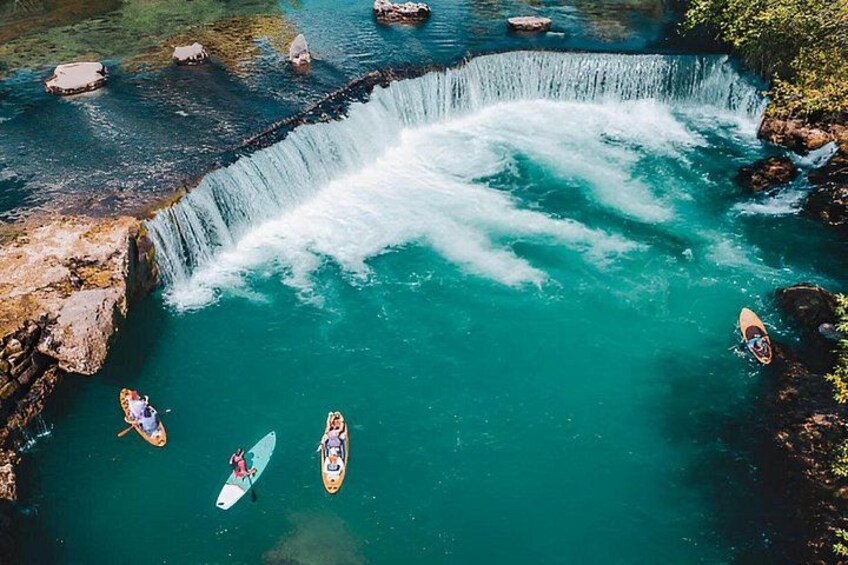 A waterfall, kayaks, and a river. 2
