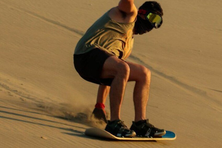 A person snowboarding down a sandy slope. 5