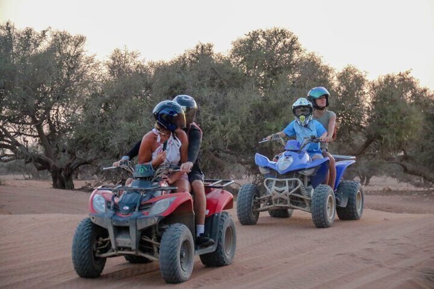 Dos personas conducen cuatrimotos por un camino de tierra con árboles al fondo. 5