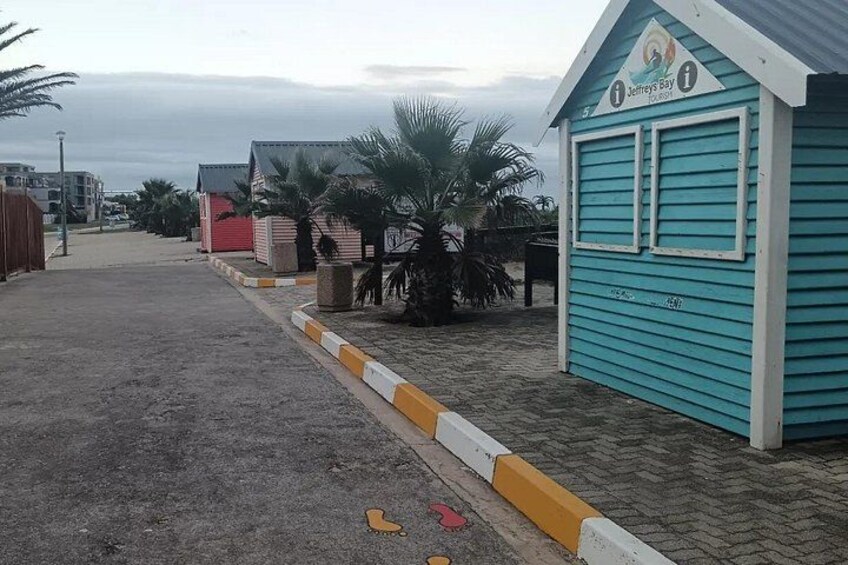 A beachside area with a turquoise building labeled 'Jeffrey's Bay,' palm trees, and a sandy path. 2