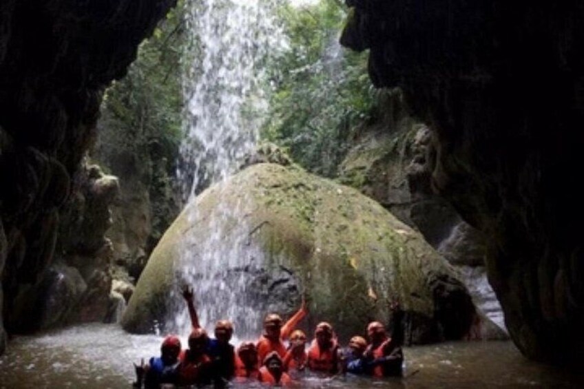 A group of people in a cave with a waterfall. 3
