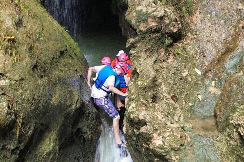 A person climbing a rocky waterfall. 4