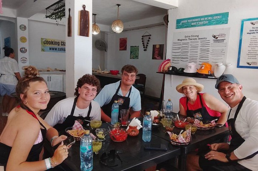 A group of people sitting at a table with food and drinks. 5