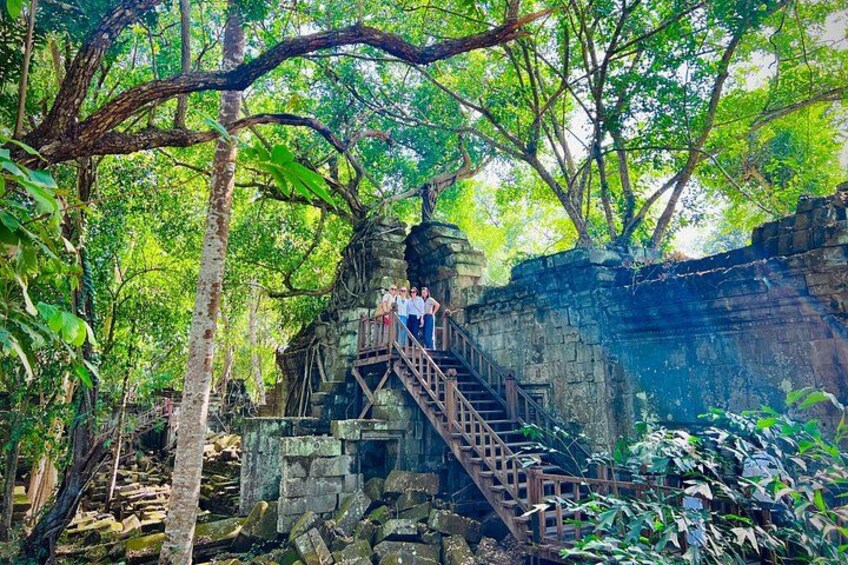 A stone staircase leading up to a temple in a forested area. 2