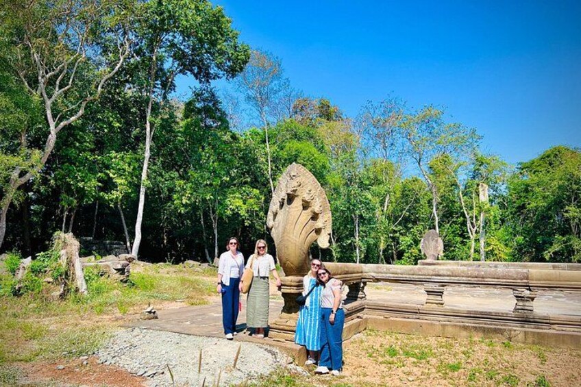 A large stone sculpture in a park with trees and a clear sky. 4