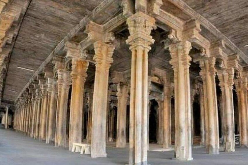 Una serie de antiguas columnas de piedra sosteniendo un techo de madera en un edificio histórico. 2