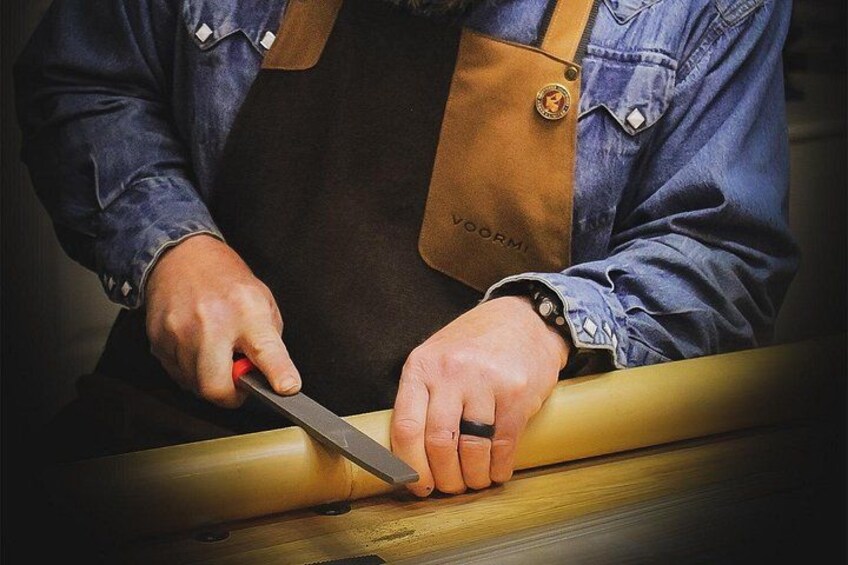 A person using a knife on a wooden surface. 3