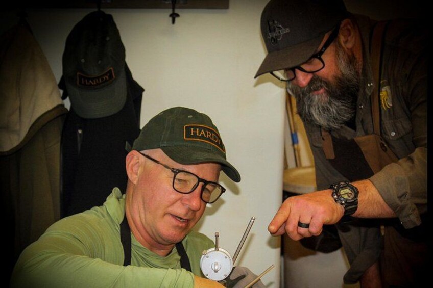 Two men wearing hats, one with a Harley logo, and a watch on the table. 4