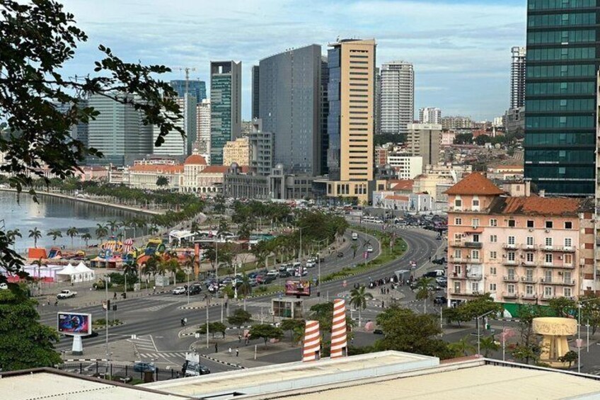 A cityscape with modern buildings, a river, and a roundabout. 1