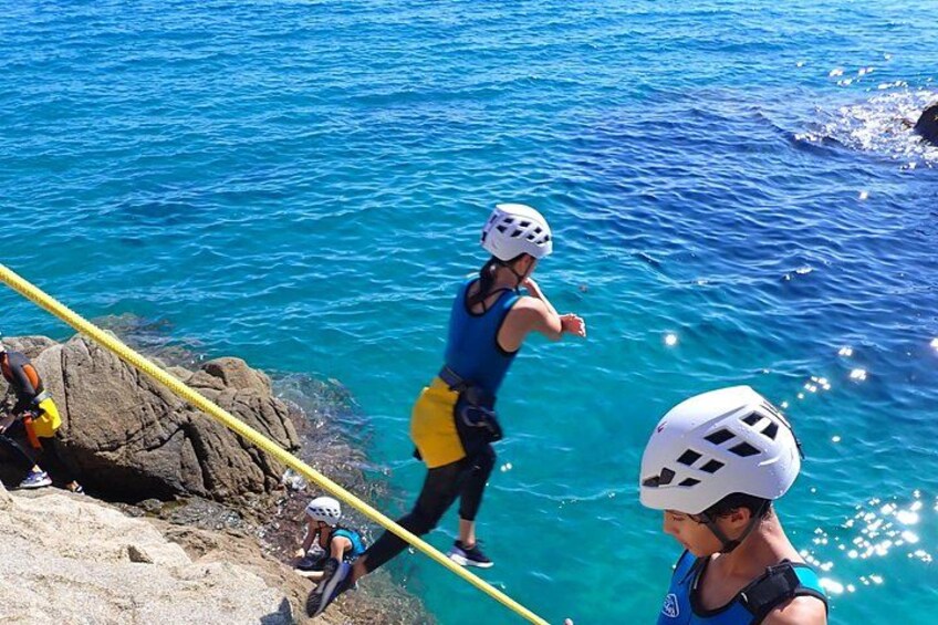 Una persona haciendo bungee jumping desde un acantilado hacia el agua. 3