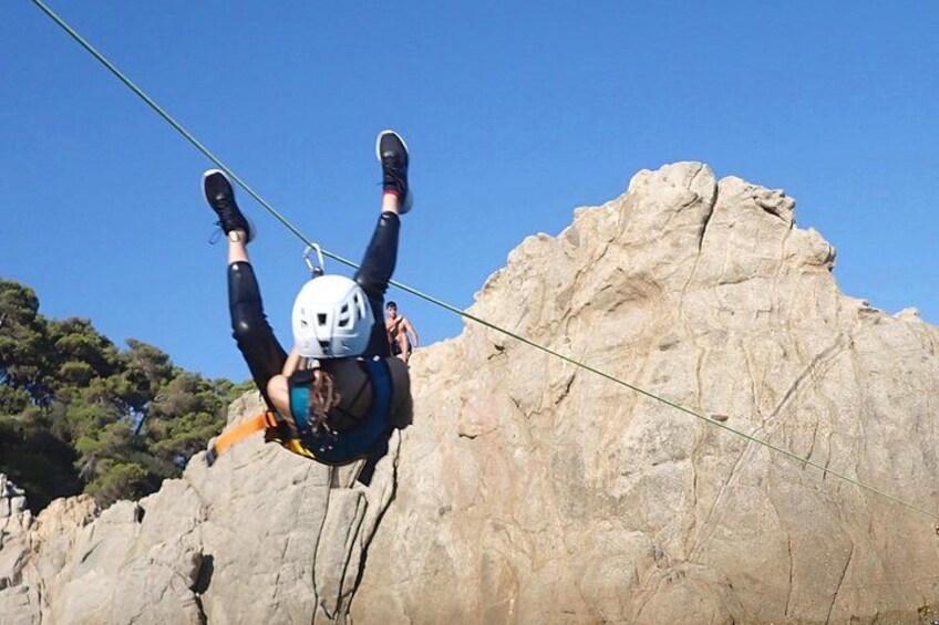 Una persona haciendo bungee jumping desde un acantilado, con un paisaje rocoso al fondo. 1