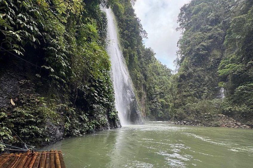 A waterfall cascading down a lush, green valley with dense foliage on either side. 1