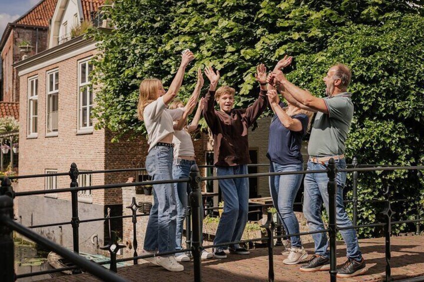 A group of people standing on a bridge, raising their hands in unison. 4