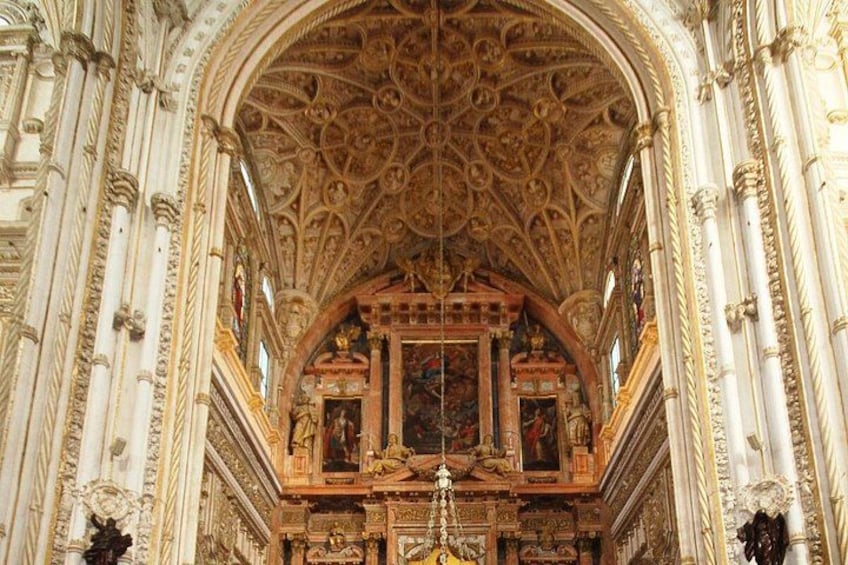 An ornate church interior with a detailed ceiling, columns, and religious artwork. 5