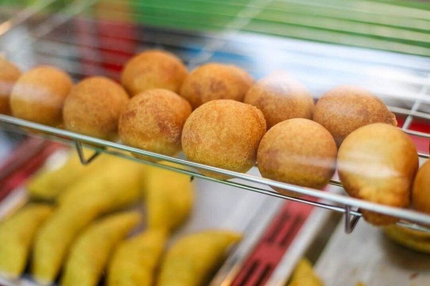 Een presentatie van ronde, goudbruine gefritte deegballetjes op een draadrek. 2